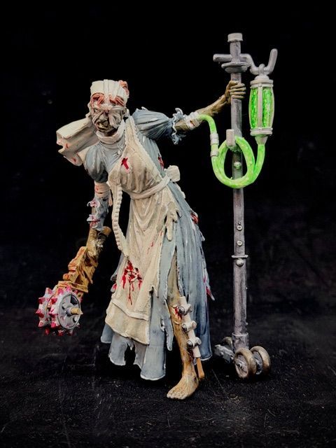 Zombie nurse figure with a mace and IV stand, wearing a tattered blue dress and apron, with a pained expression.