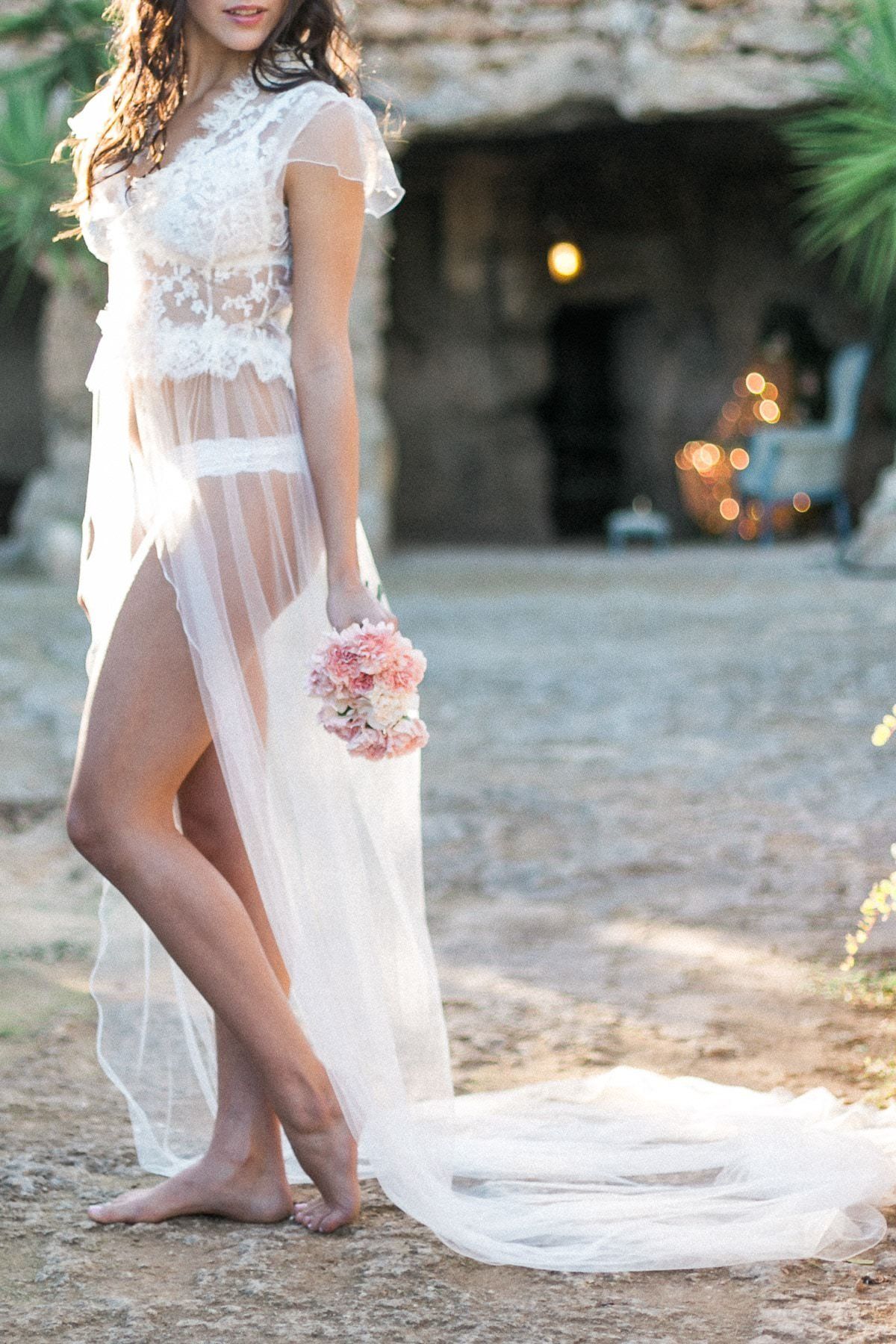 A woman in a white dress is holding a bouquet of flowers.