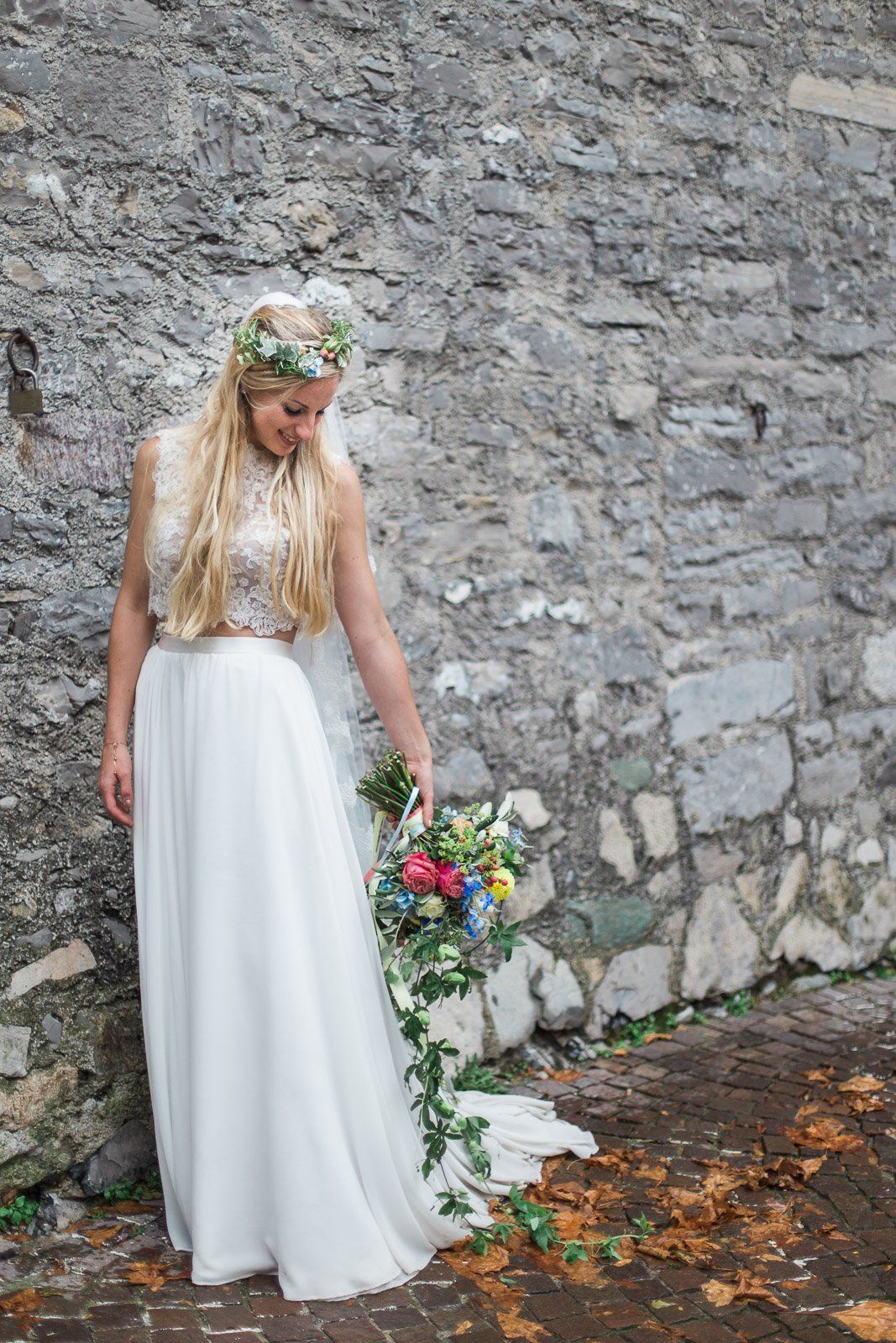 The bride is wearing a flower crown and holding a bouquet of flowers.