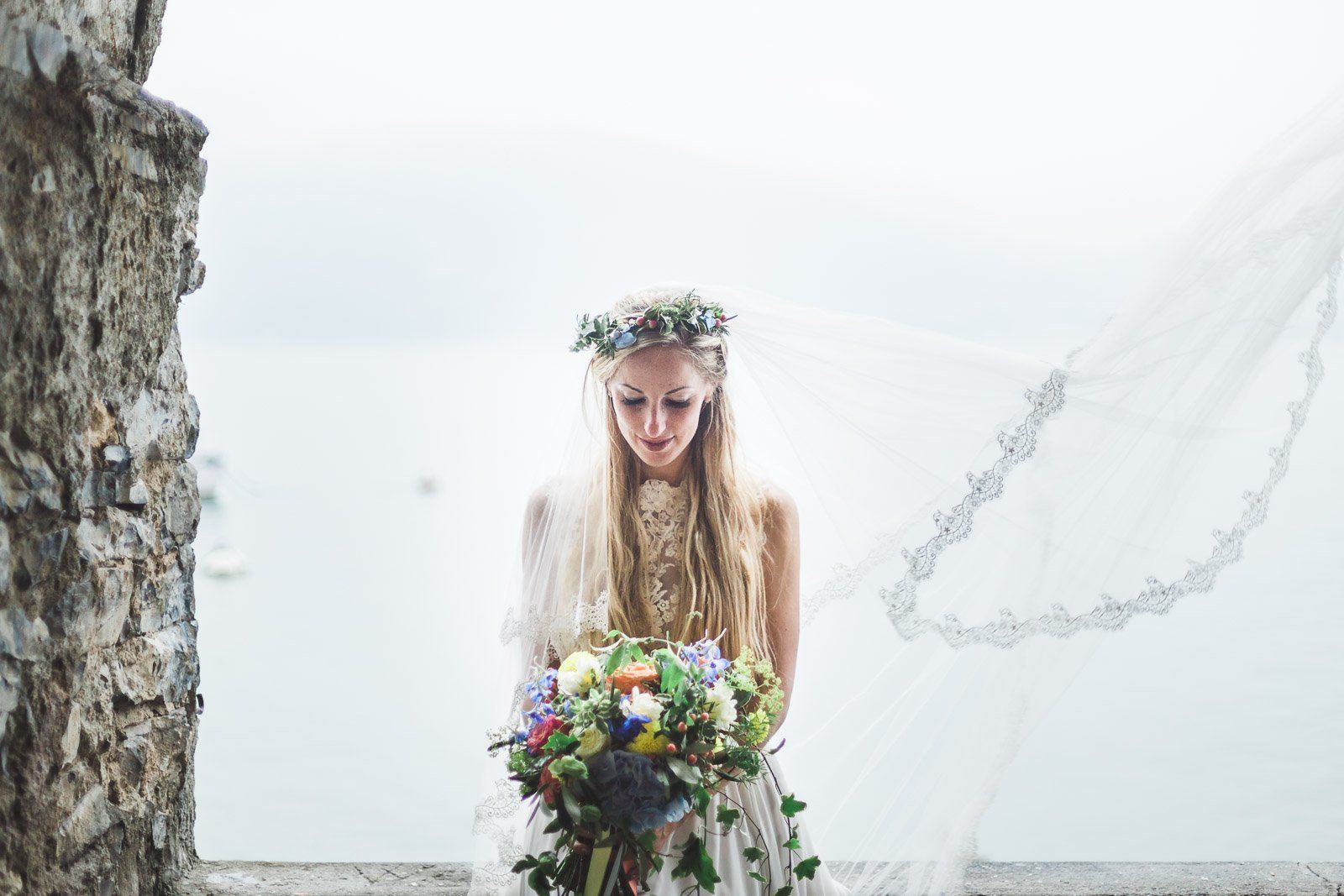 The bride is wearing a flower crown and holding a bouquet of flowers.