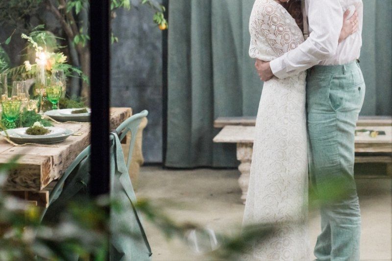 A bride and groom are hugging each other in a room.