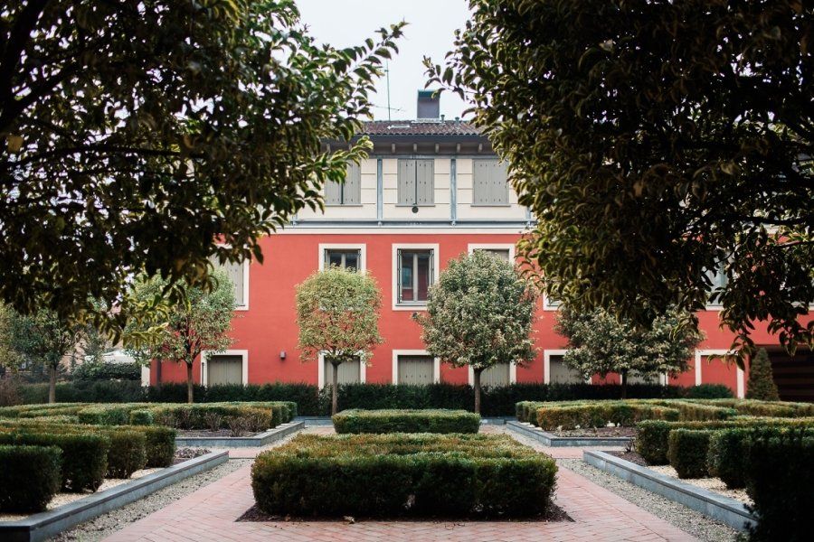 A red building with a garden in front of it
