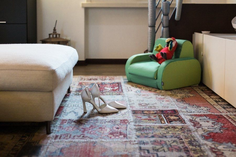 A pair of shoes sitting on a rug next to a chair.