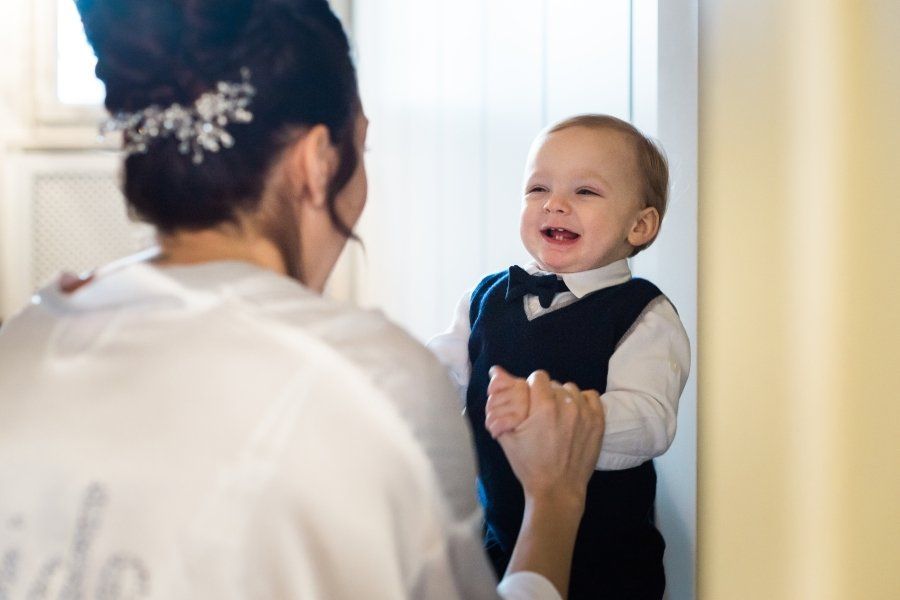 A woman is holding a baby in her arms and the baby is wearing a bow tie.