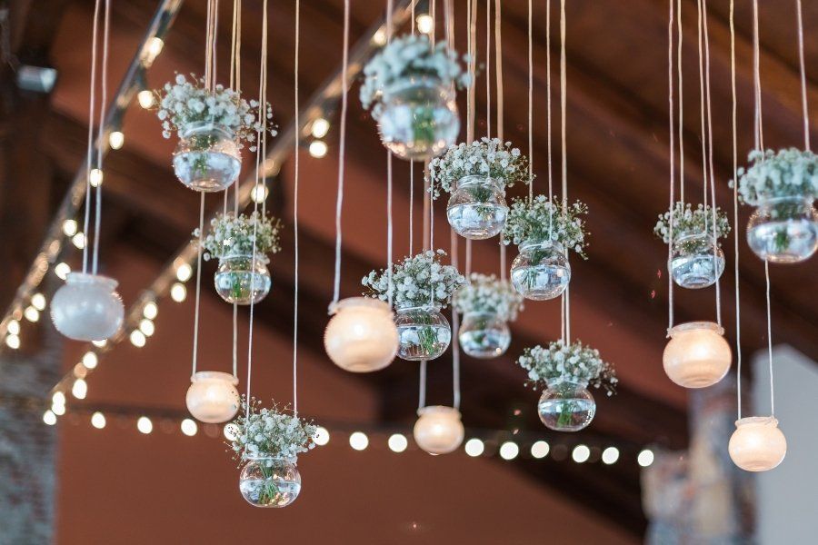 A bunch of vases with flowers hanging from the ceiling
