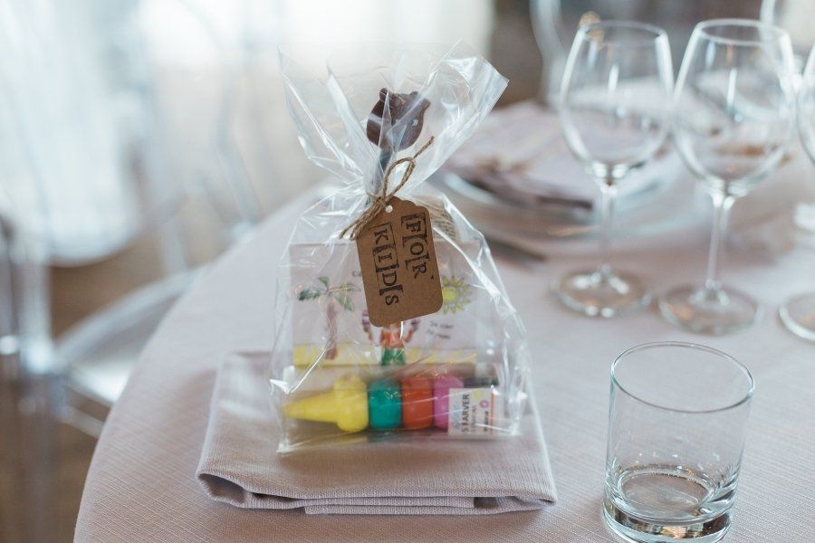 A bag of crayons is sitting on a table next to a glass of water.