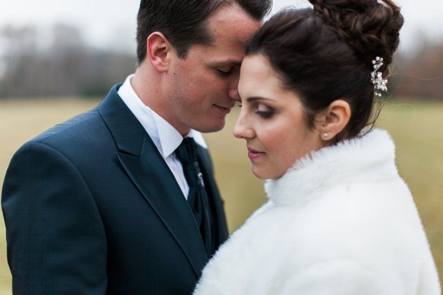A bride and groom are looking at each other in a field.