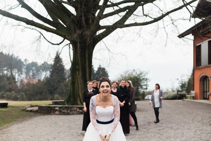 A bride and her bridesmaids are posing for a picture in front of a tree.