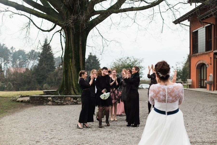 A bride and her bridesmaids are posing for a picture in front of a tree.