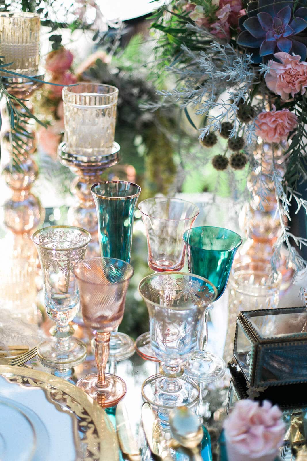 There are many different colored wine glasses on the table.