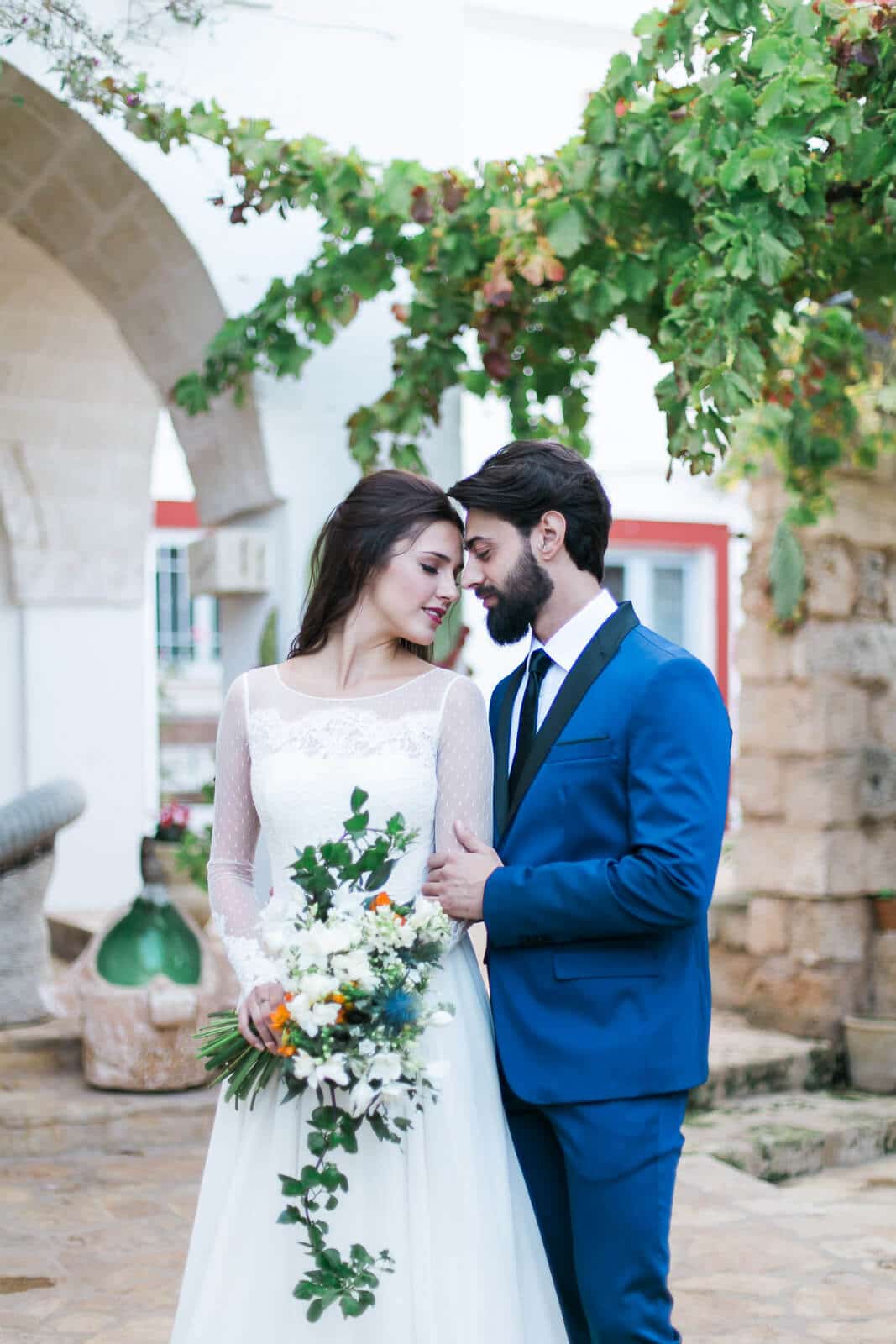 A bride and groom are standing next to each other in front of a building.