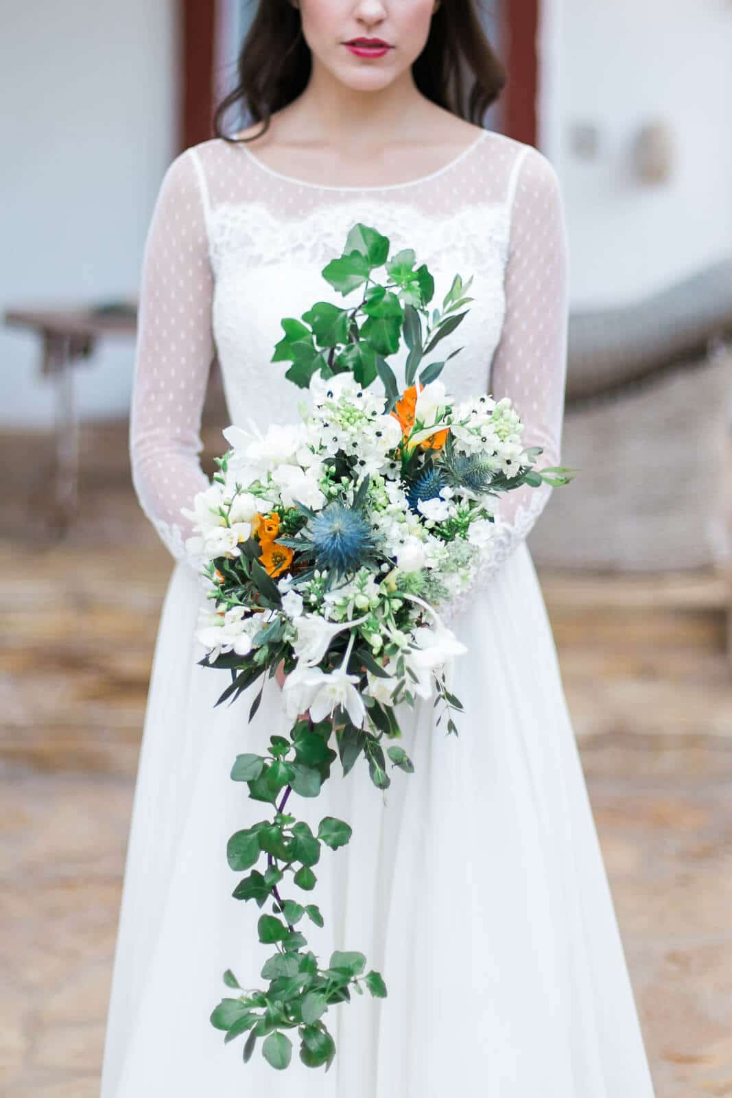 A bride in a white dress is holding a bouquet of flowers.