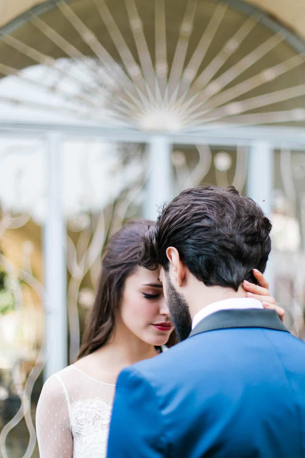 A bride and groom are standing next to each other in front of a gazebo.
