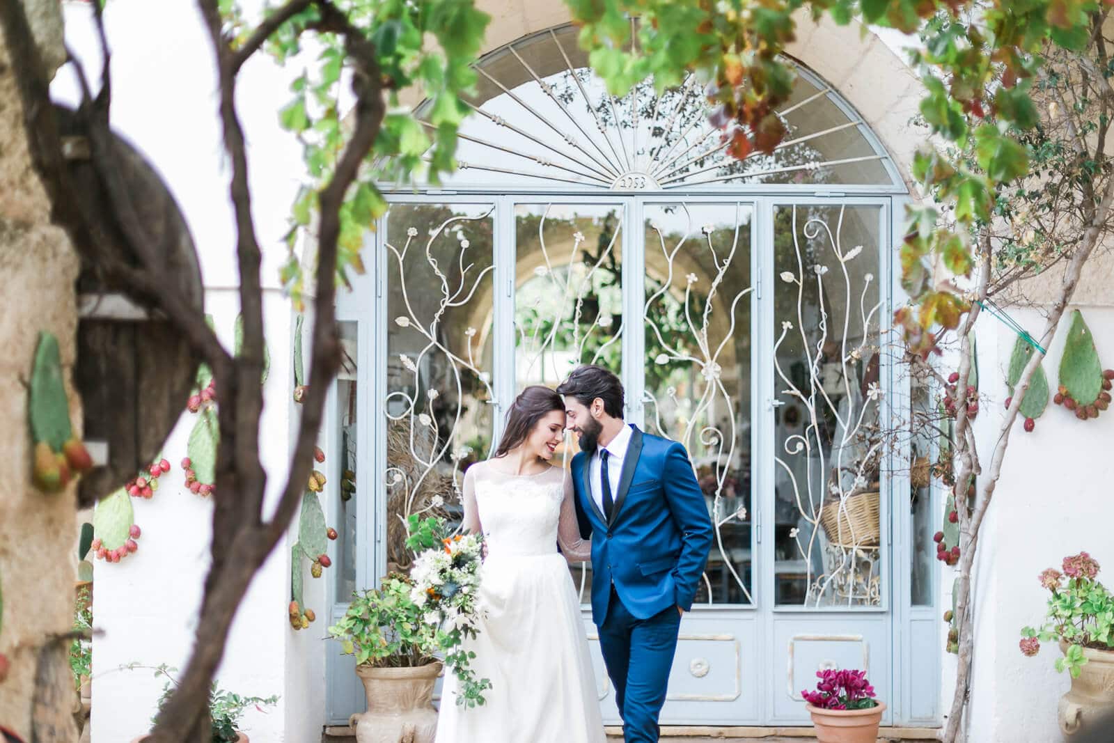 A bride and groom are posing for a picture in front of a building.
