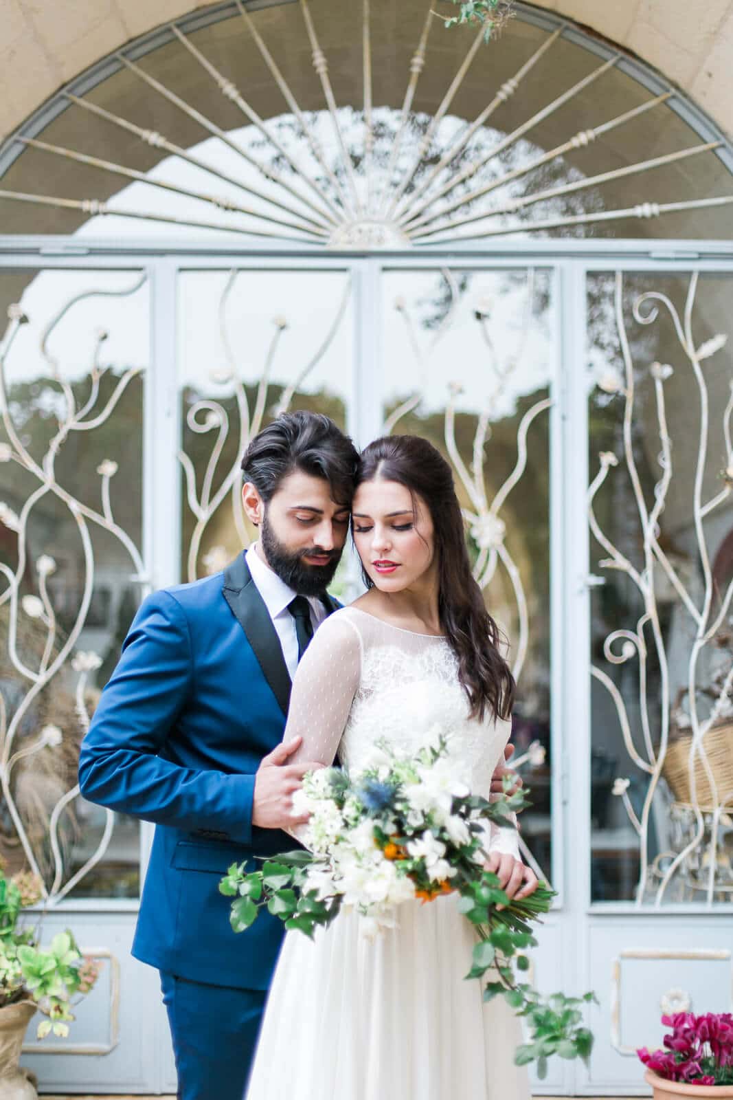 A bride and groom are posing for a picture in front of a glass door.