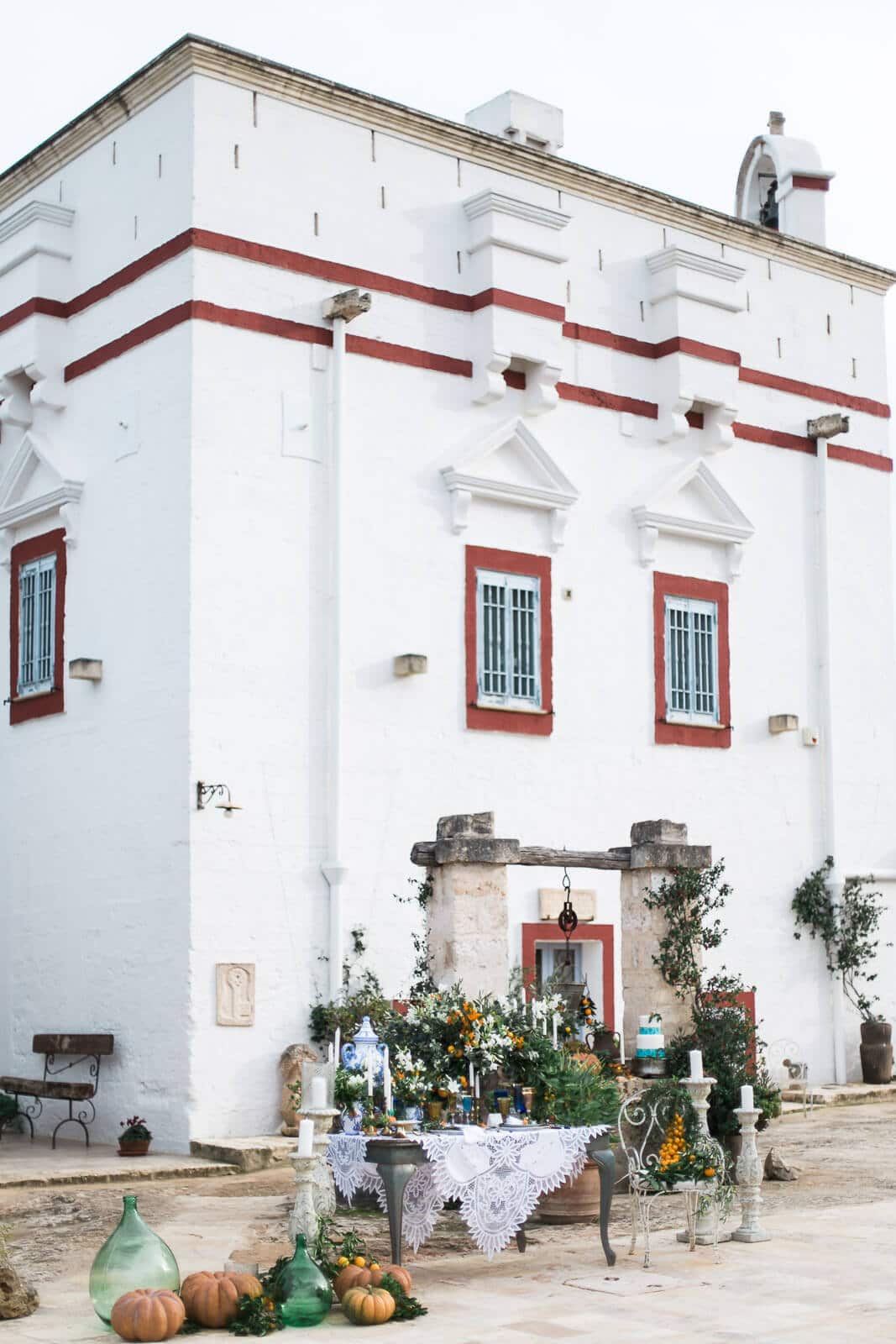 A white building with red trim and a table in front of it