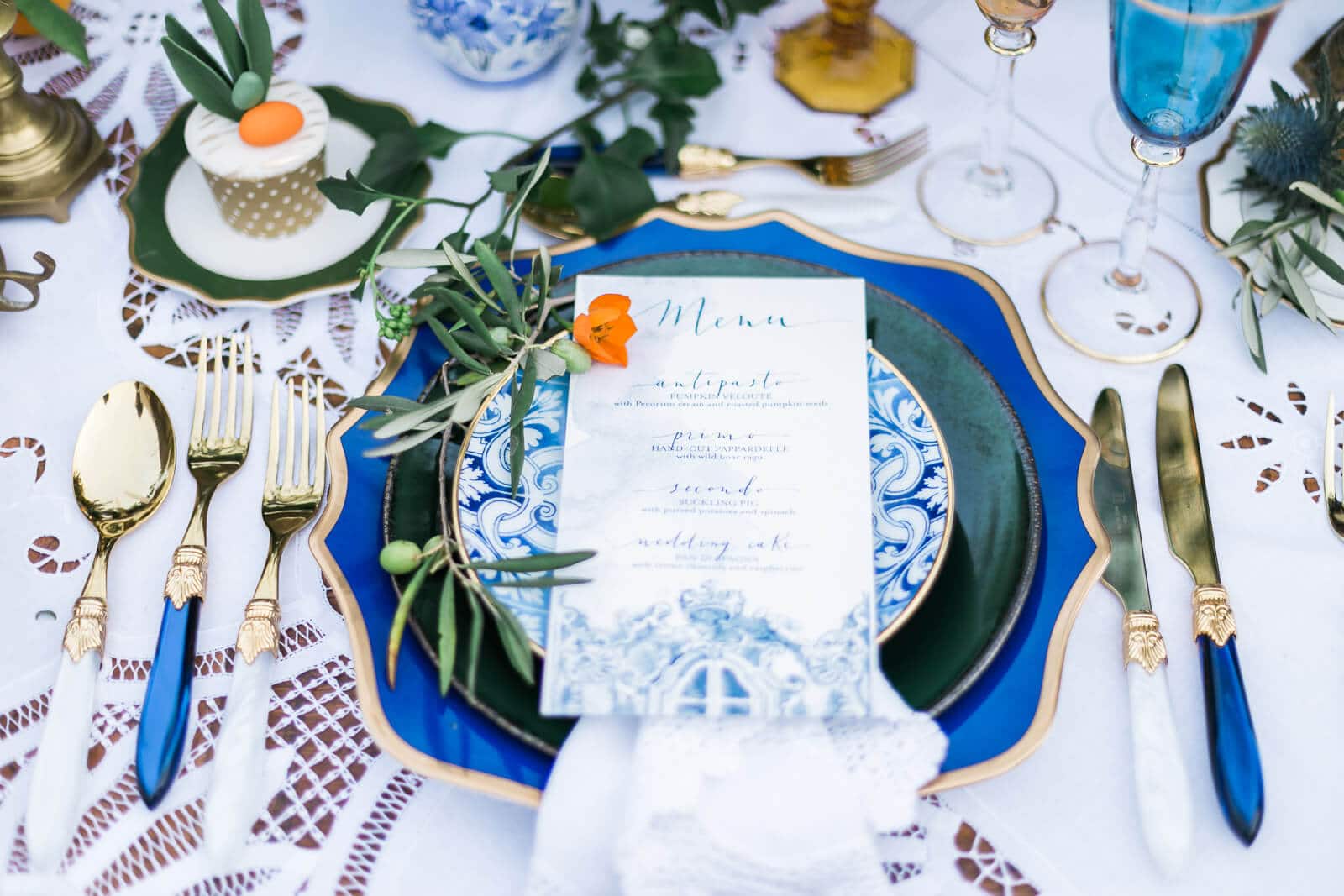 A table with plates , silverware , and a menu on it.