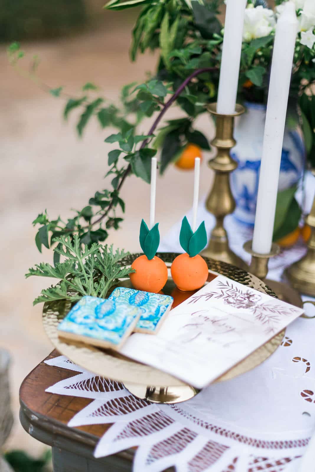 A table with a tray of cake pops and candles on it.