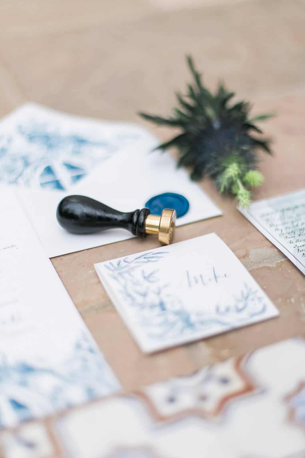 A wax seal is sitting on top of a piece of paper on a table.