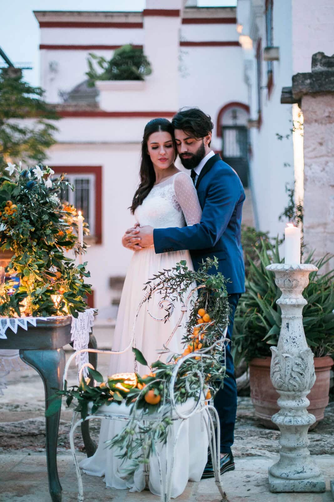 A bride and groom are posing for a picture in front of a building.