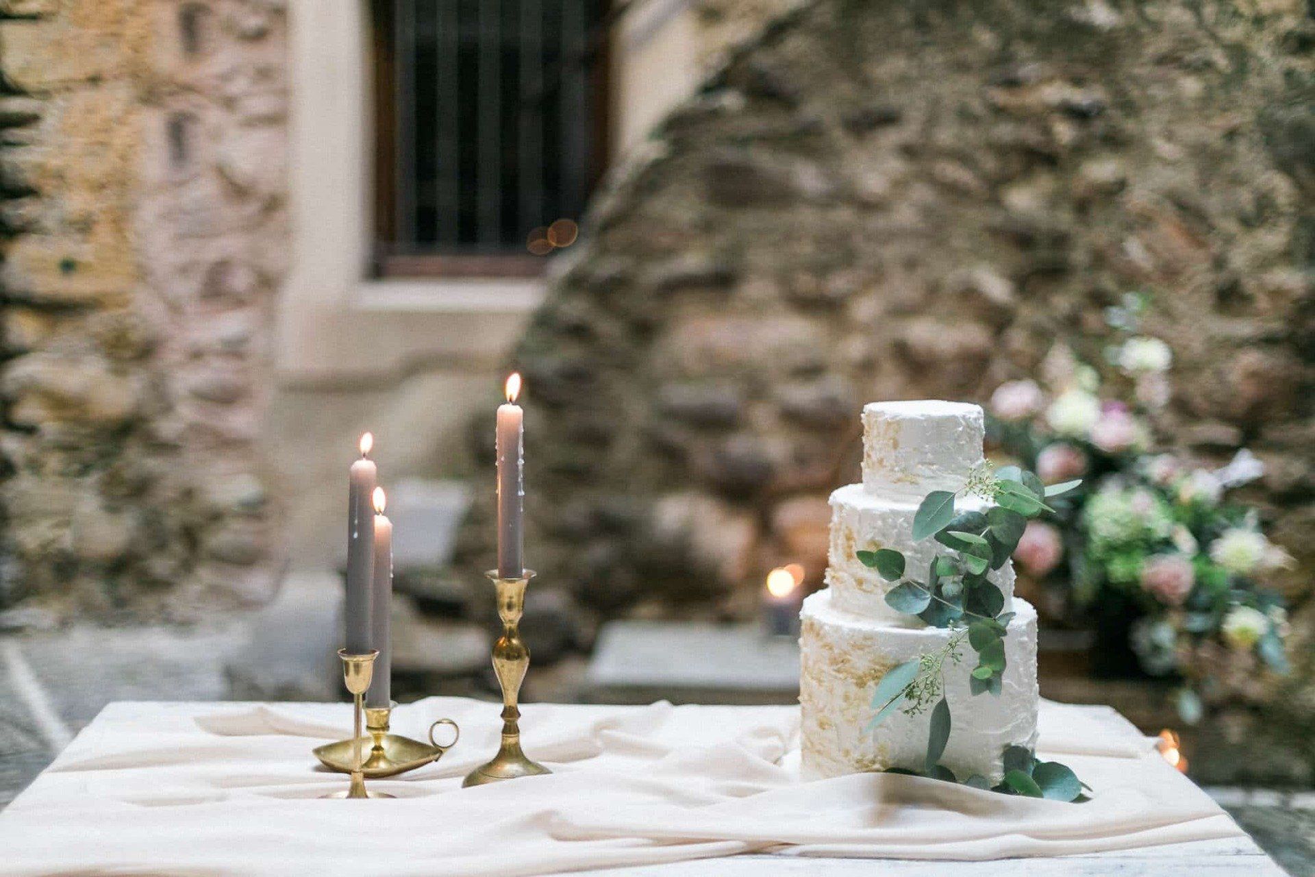 A wedding cake is sitting on a table next to candles.