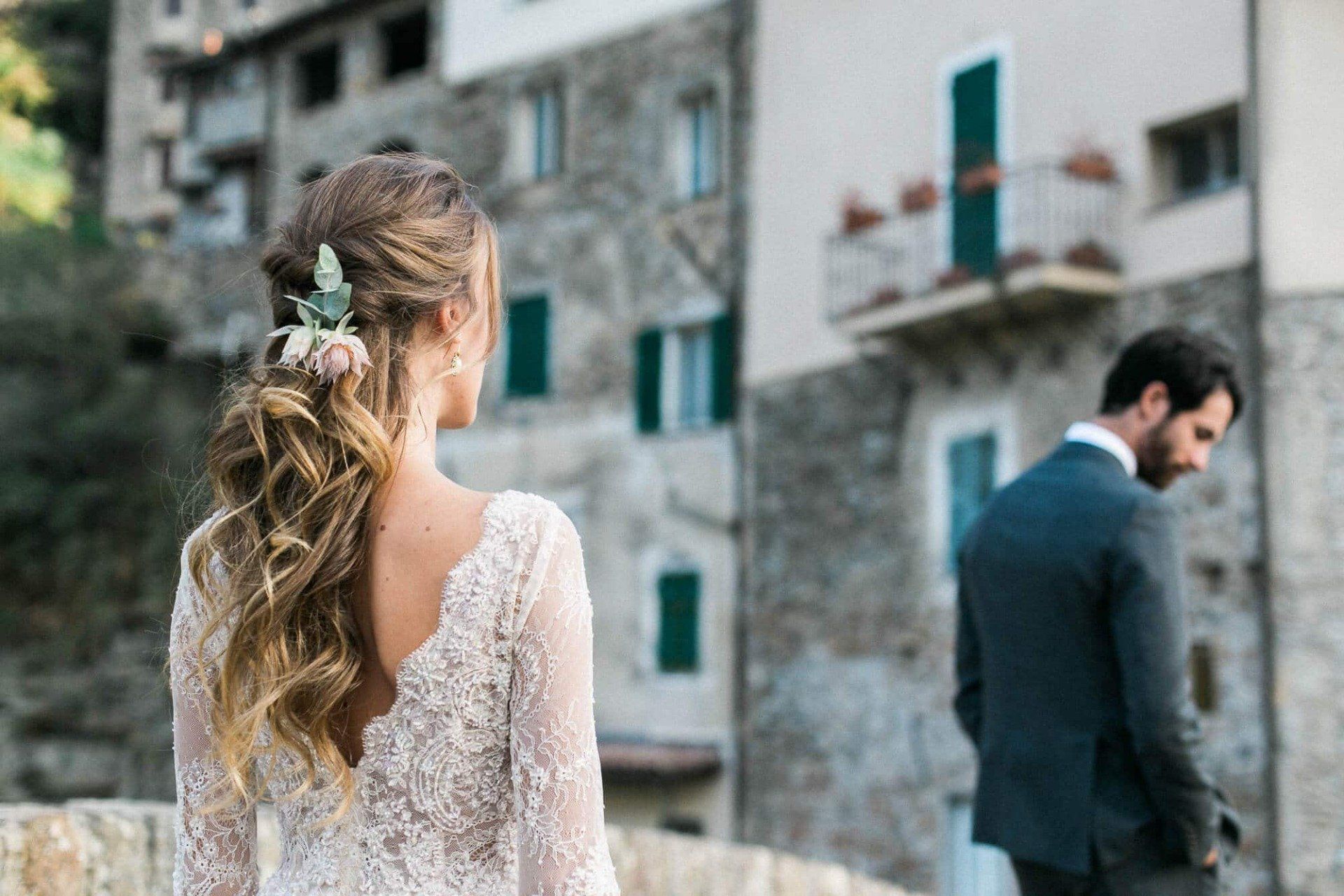 A bride and groom are standing next to each other in front of a building.