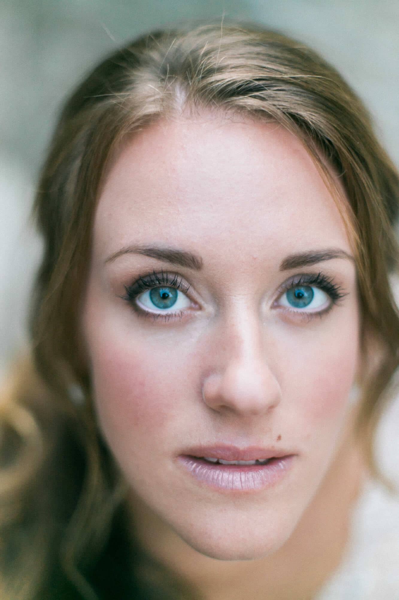 A close up of a woman 's face with blue eyes.