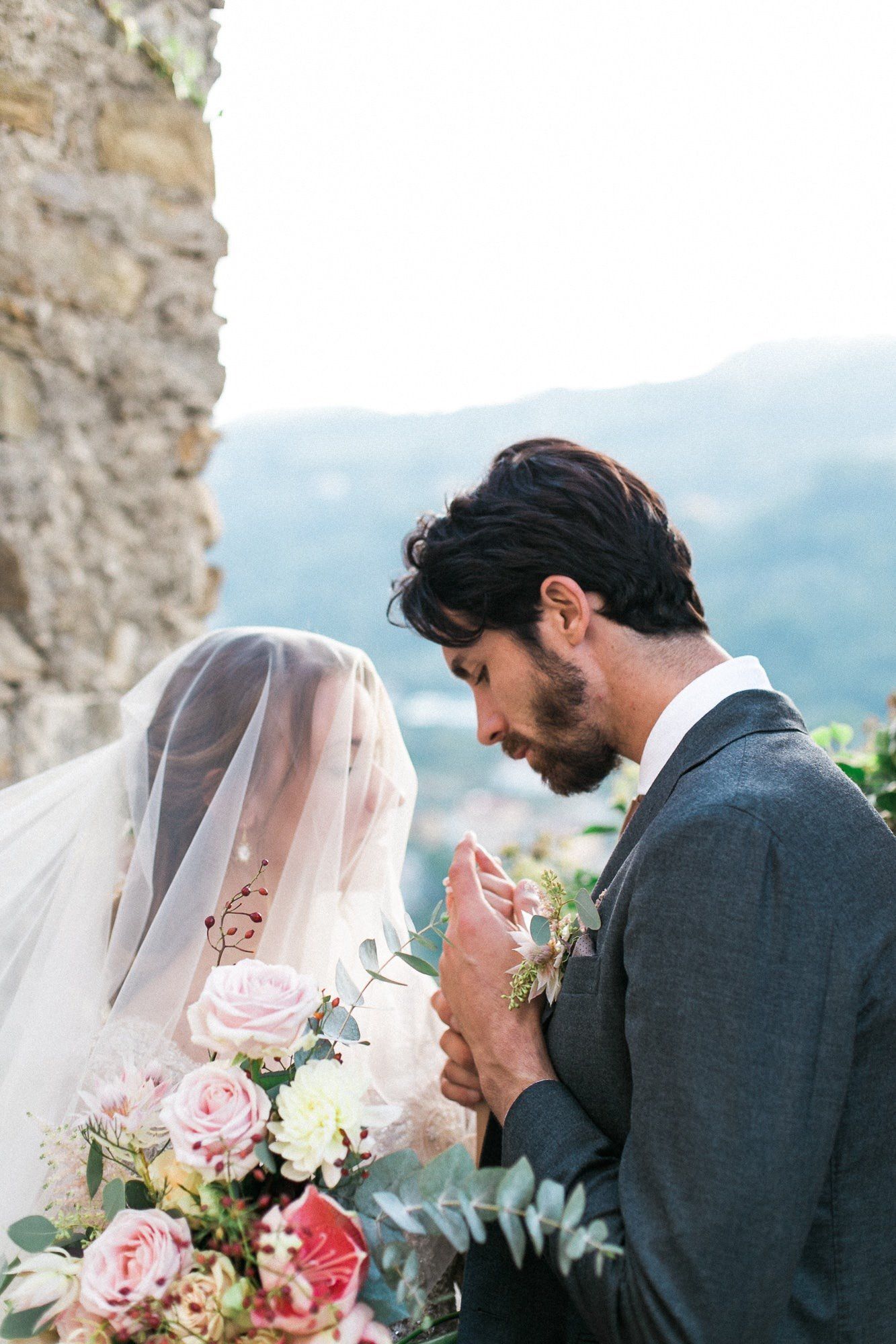 A bride and groom are holding hands and looking at each other.