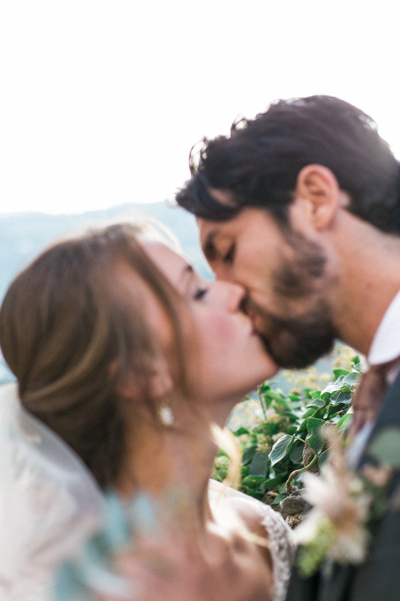A bride and groom are kissing on their wedding day.