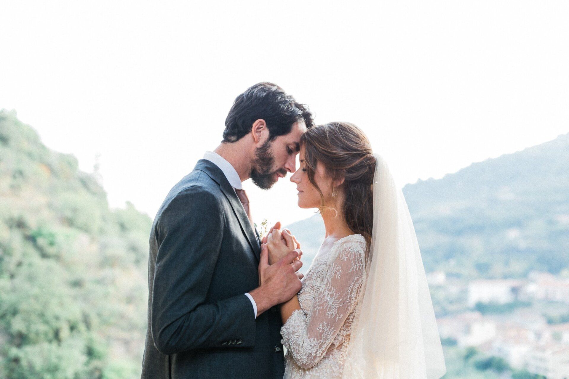 A bride and groom are holding hands and looking at each other.