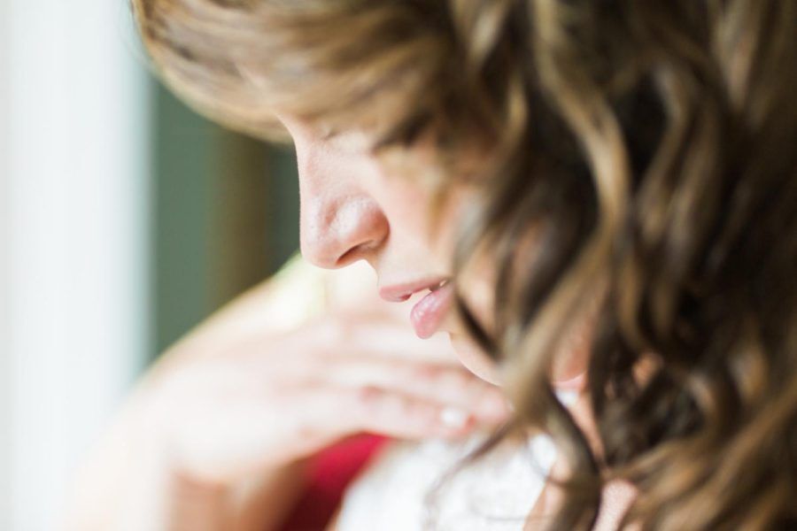 A close up of a woman 's face with her hand on her chest.