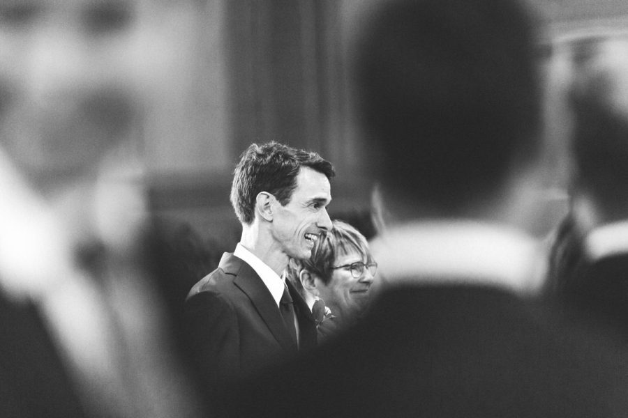 A man in a suit and tie is standing in a crowd of people.