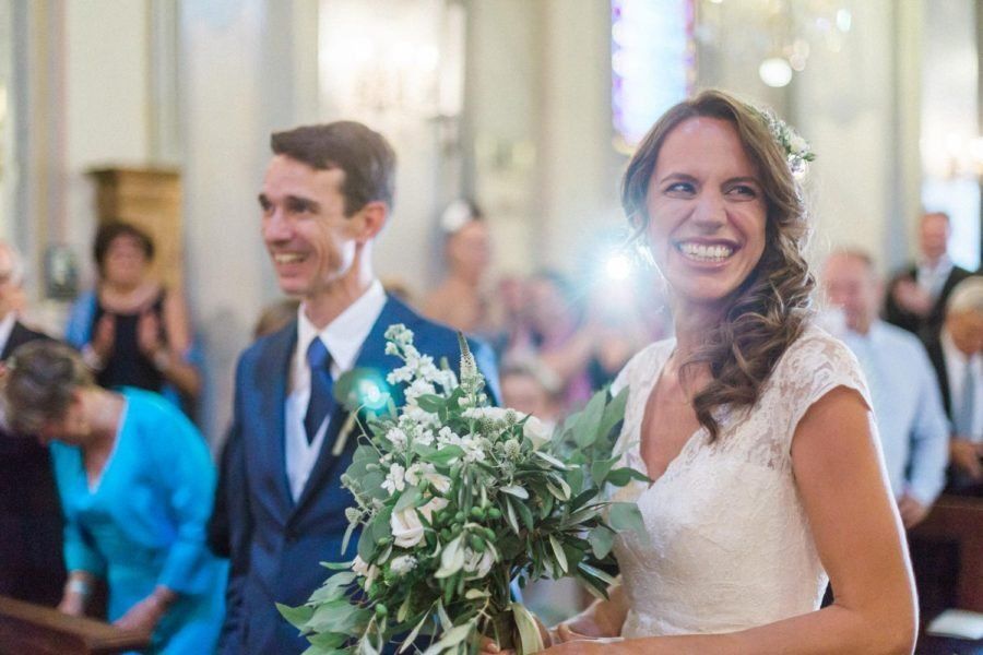 A bride and groom are walking down the aisle at their wedding in a church.