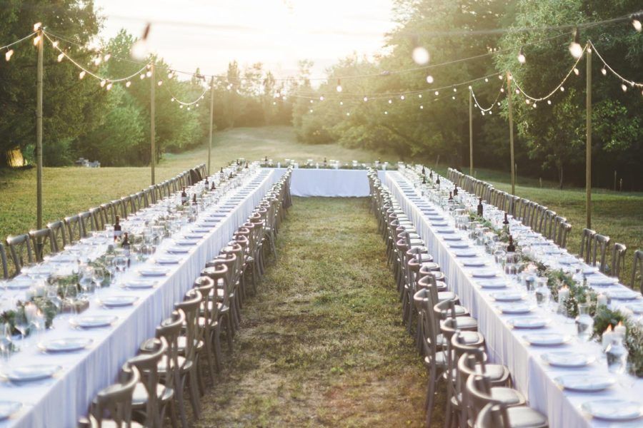 A long table set for a wedding reception in a field.