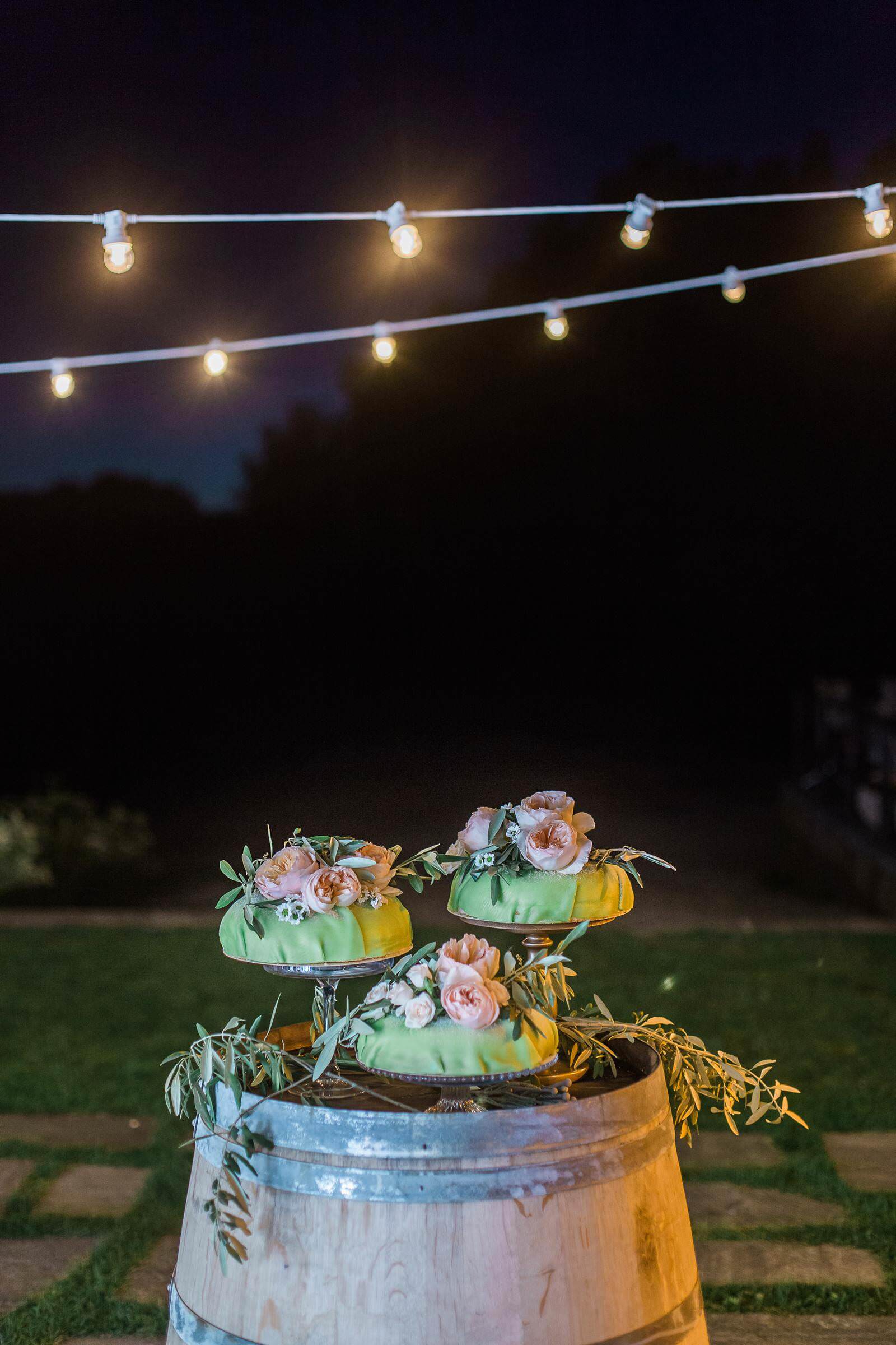 Three cakes are sitting on top of a wooden barrel.