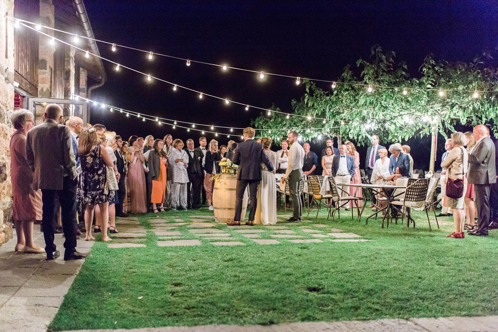 A group of people are standing in a grassy area at night.