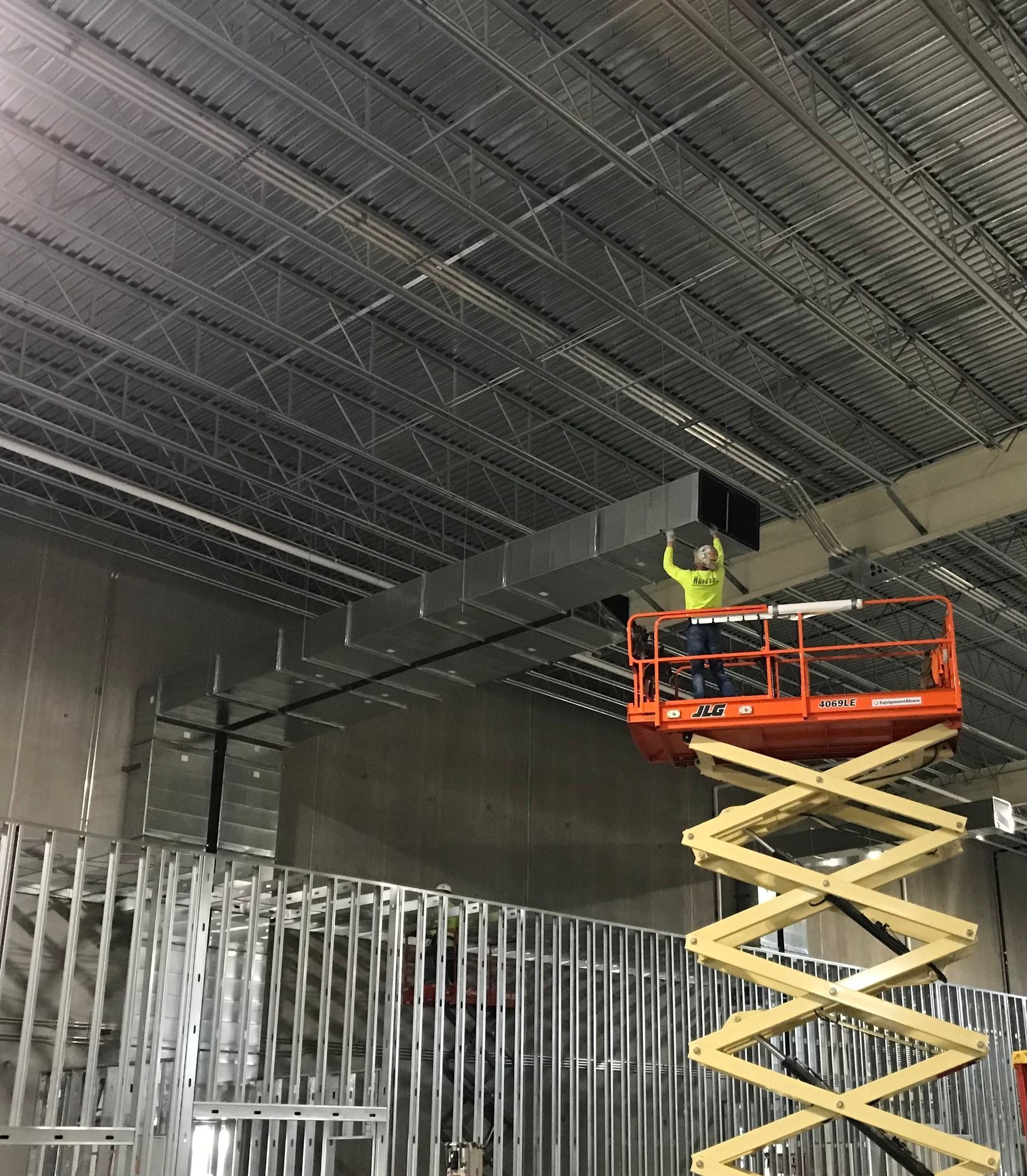 A Worker on a Lift Working on Custom Ductwork at a Missouri Business. Call Hulett to Learn More.