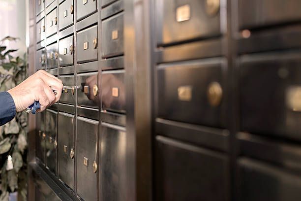 A person is opening a safe in a bank with a key.