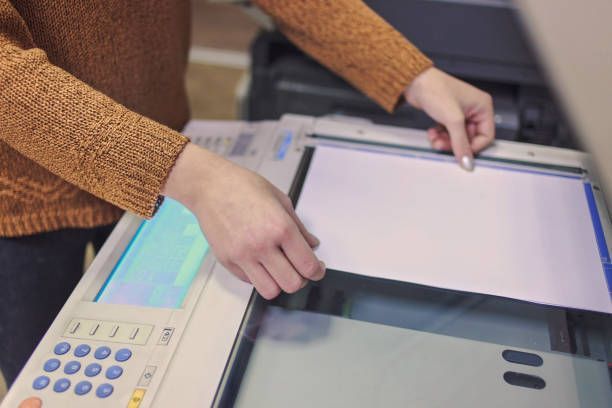 A woman is sitting at a table with a box and a tablet.