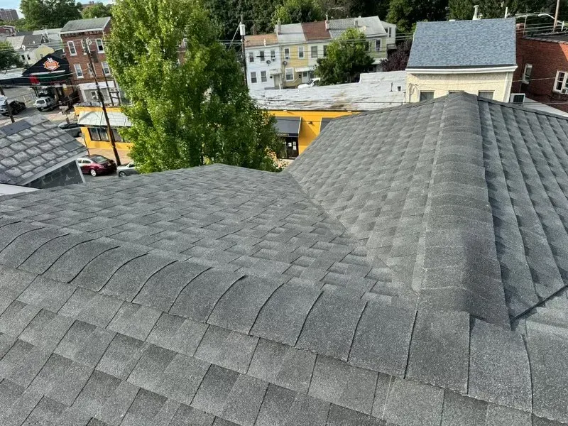 A roof with a lot of shingles on it and a city in the background.