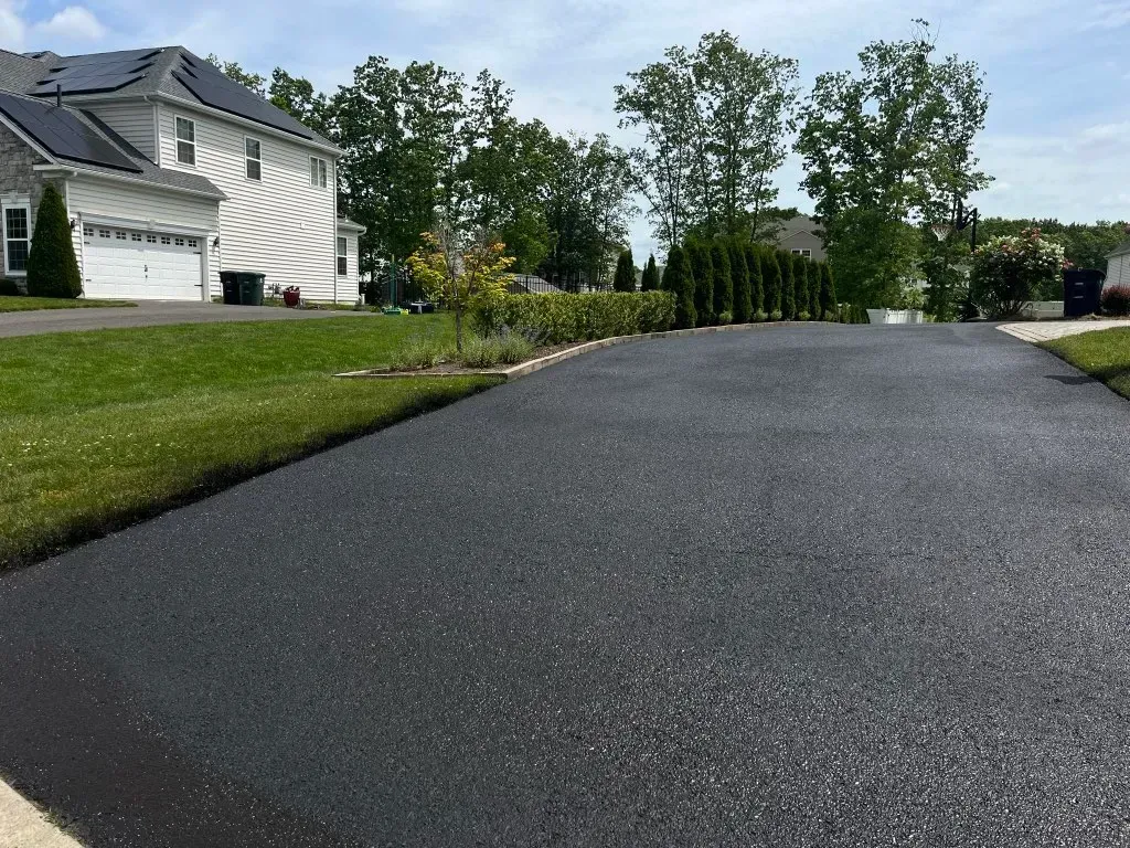 A driveway leading to a house with solar panels on the roof