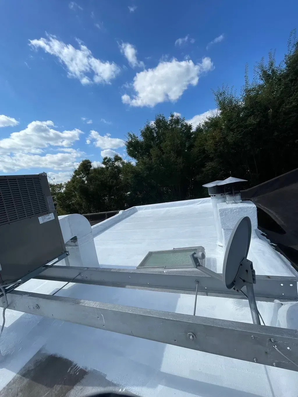A white roof with a satellite dish on top of it.