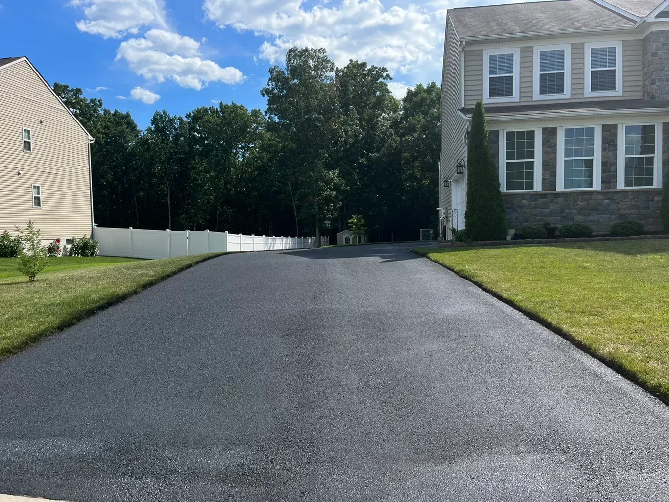 A driveway leading to a large house with a lot of windows