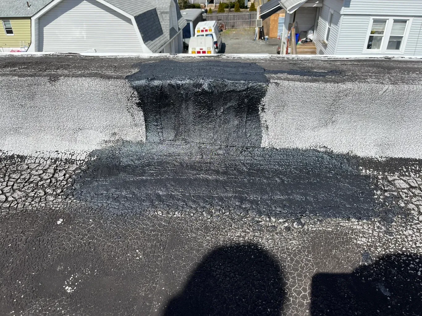 A shadow of a person is cast on the roof of a house.