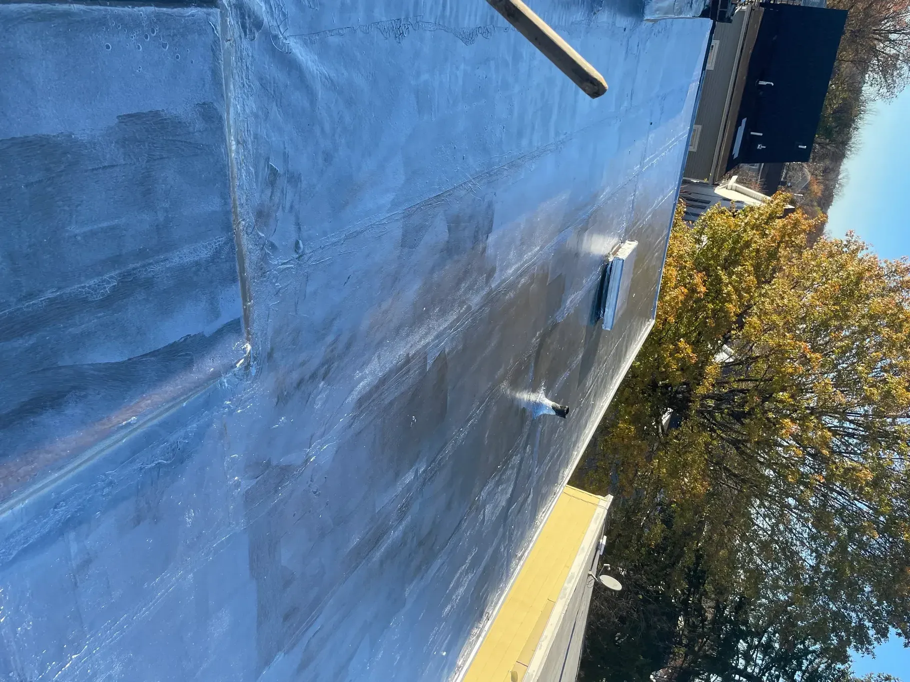 A close up of a roof with a blue tarp on it.