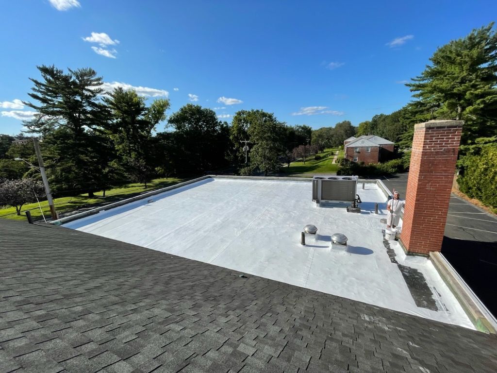 A large wooden deck with a white railing and a white house in the background.