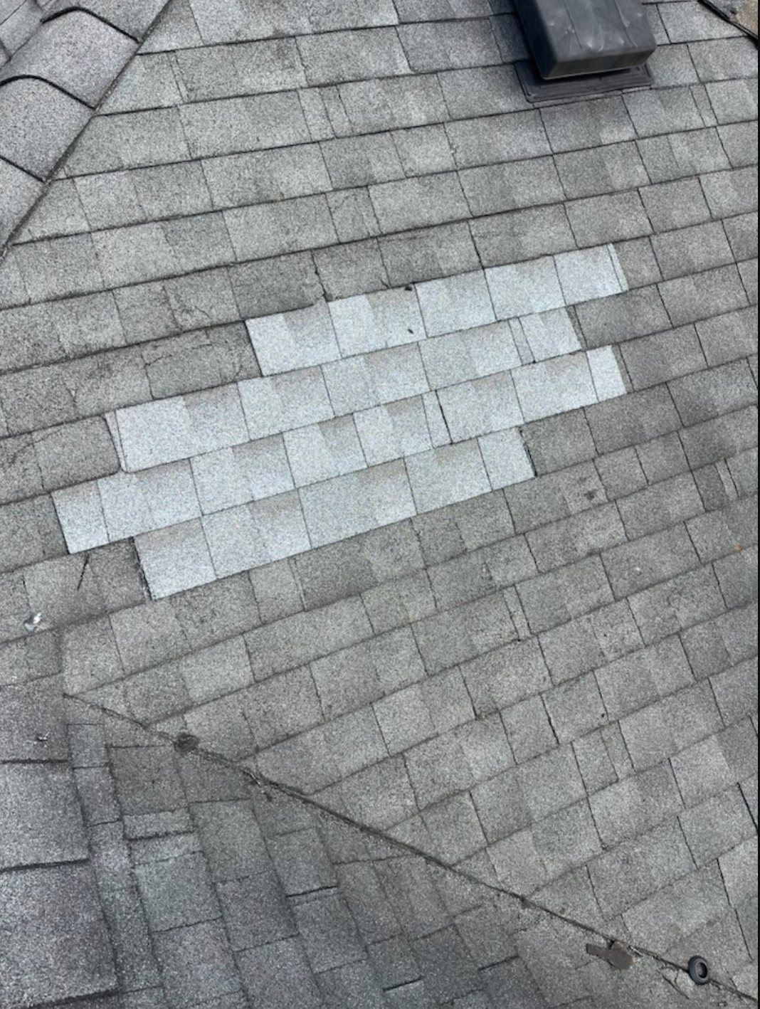 A ladder is sitting on top of a white roof next to a building.