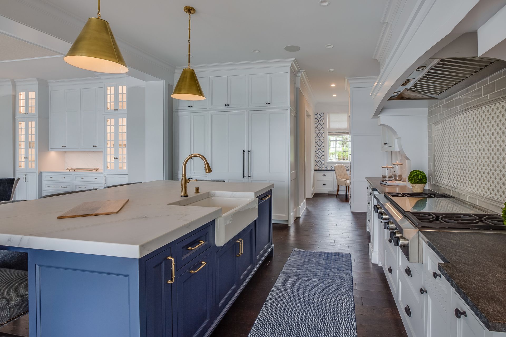 A kitchen with blue cabinets , white cabinets , and a large island.