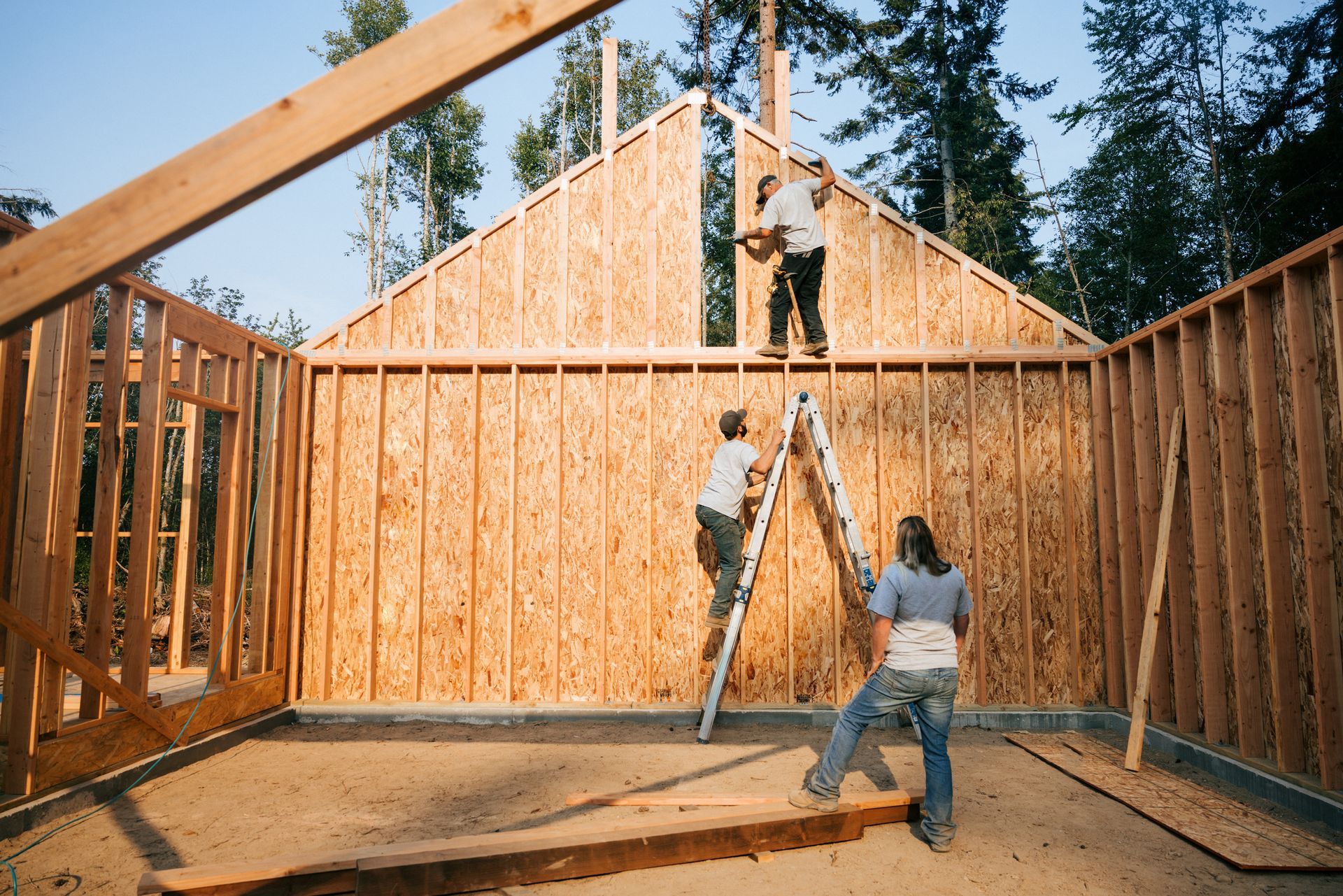 A group of people are working on a house that is being built.