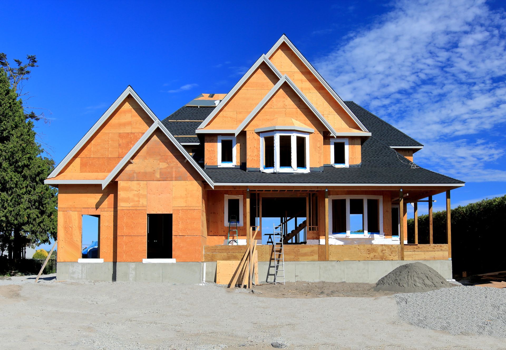 A large house under construction with a blue sky in the background.